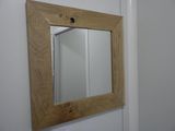 un miroir sur le mur au-dessus d'un lavabo dans une salle de bains