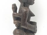 statue of a woman sitting on a stool with a cat on her lap