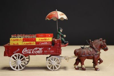 a toy horse pulling a cart with coca cola on it
