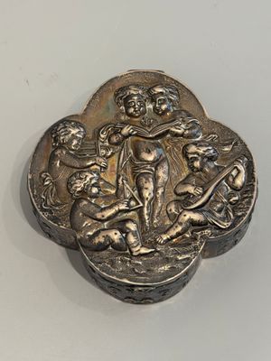 une vieille boîte en argent posée sur une table blanche