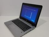 a laptop computer sitting on a white table with a blue screen