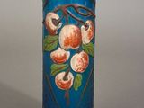 un vase bleu orné d'une peinture représentant des fruits