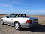 a silver convertible car parked on the side of the road