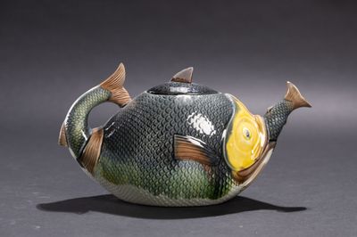 une théière en forme de poisson avec une nageoire jaune