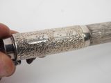 a person holding a silver object with writing on it