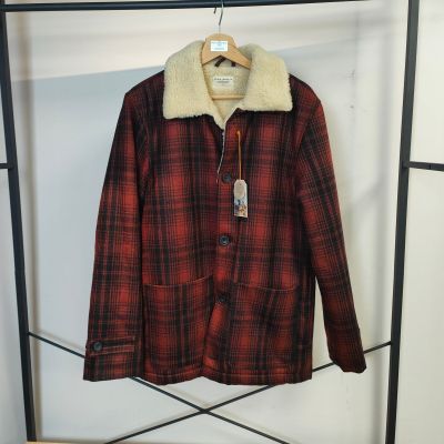 La veste est suspendue à un portant et porte une étiquette.