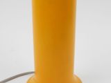 yellow table lamp on a white surface with a cord connected to it