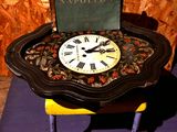 une petite table sur laquelle se trouvent une horloge et un livre