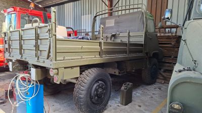 a green truck that is parked in a garage