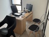 a desk with two chairs and a computer on top of it