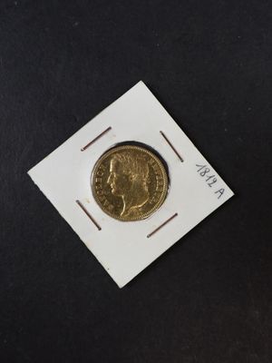 un gros plan d'une pièce d'or posée sur une carte blanche