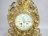 a gold clock that is sitting on a table