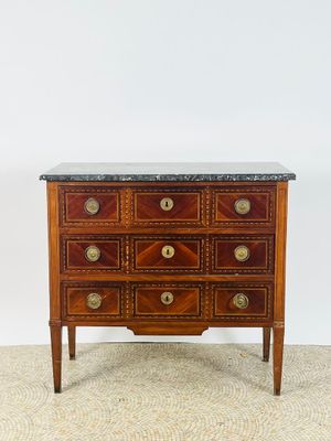une commode ancienne avec dessus en marbre et poignées en laiton