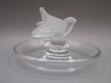 une plaque de verre sur laquelle est représenté un oiseau, posée sur une table