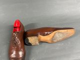 pair of brown leather shoes with red soles sitting on a gray surface