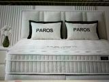 two pillows on the bed that say paros and paros