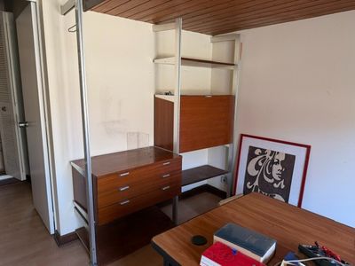 une photo d'une chambre avec un bureau et une bibliothèque
