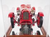 a red model of a race car in a glass case