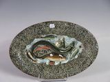 une assiette sur laquelle sont représentés un poisson et un serpent