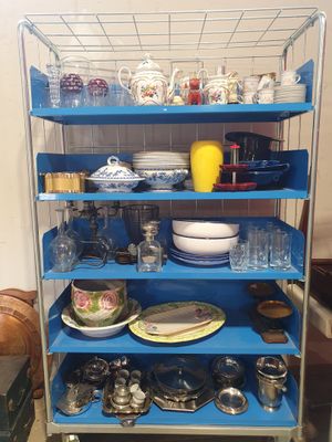 un chariot bleu sur lequel sont posés de la vaisselle et des tasses