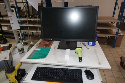 a computer desk with a monitor, keyboard and mouse on it