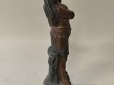 a statue of a man holding a bird on top of a table