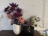 deux vases contenant des fleurs, posés sur une table