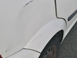 the rear end of a white car with a denting dent