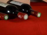 several bottles of wine are lined up on a red table