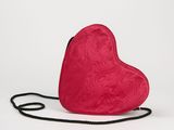 un sac à main rouge en forme de cœur posé sur une surface blanche