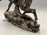 statue of a man riding a horse on a rock on a white background