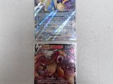 a close up of two pokemon cards on a white surface