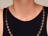 a woman wearing a black tank top and a gold chain necklace