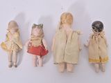 several small dolls are lined up in a row on a white surface