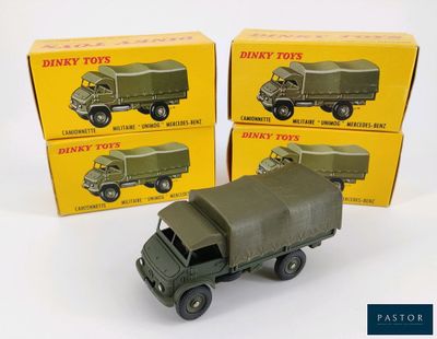Trois véhicules militaires « Dinky Toys » dans leur boîte sont exposés dans une boîte.