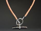 a close up of a leather necklace with a silver clasp