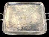 un plat ancien en argent avec des poignées, sur fond noir