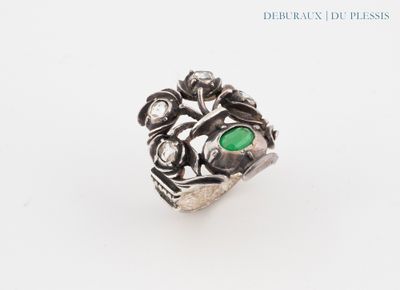 a close up of a ring with a green stone in it