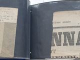 an open book with stamps on it sitting on top of a table