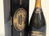 une image représentant une bouteille de champagne posée à côté d'une boîte