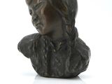 bronze bust of a young girl with a hat on her head