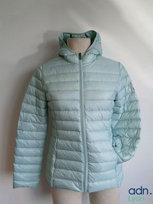 the jacket is light blue and has a hood that is attached to a mannequin