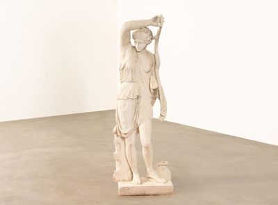 une statue de femme tenant un oiseau dans sa main