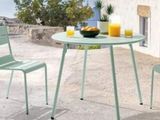 a table with two chairs and a bowl of fruit on it