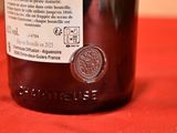 a bottle of wine sitting on a table with a red cloth