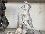 deux statues d'hommes posées sur une étagère dans une pièce
