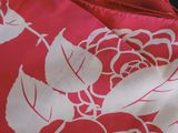 a close up of a red and white bag with flowers on it