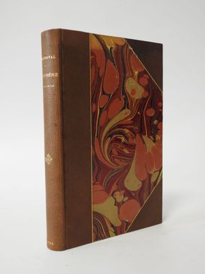 a brown book sitting on top of a white table next to a white wall