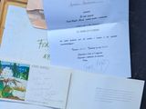 many papers and envelopes on a table with a pen