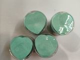 trois bocaux aux couvercles verts sont posés sur une surface blanche